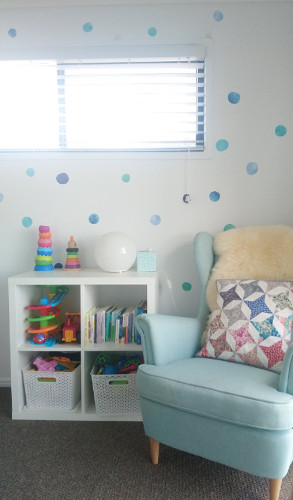 Progress shot of the reading chair and toy storage in the room with the wall stickers added