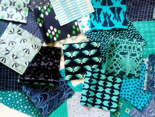 Randomly arranged fabric swatches in varying shades of blues and greens.